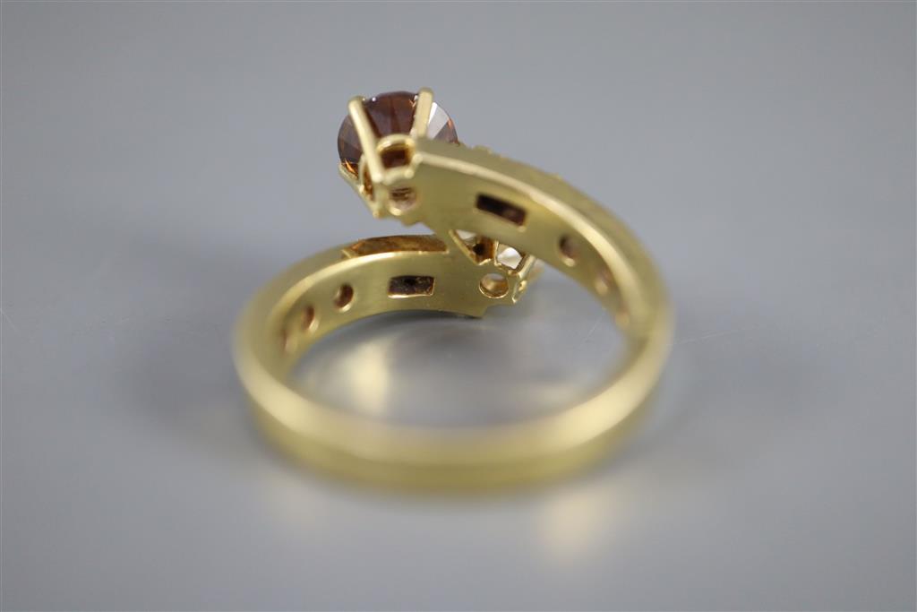 A modern yellow metal and two colour diamond two stone crossover ring,
